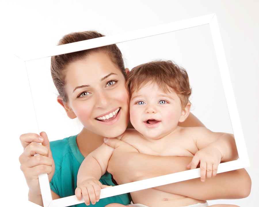 Photo of attractive female holding in hands cute baby boy, close